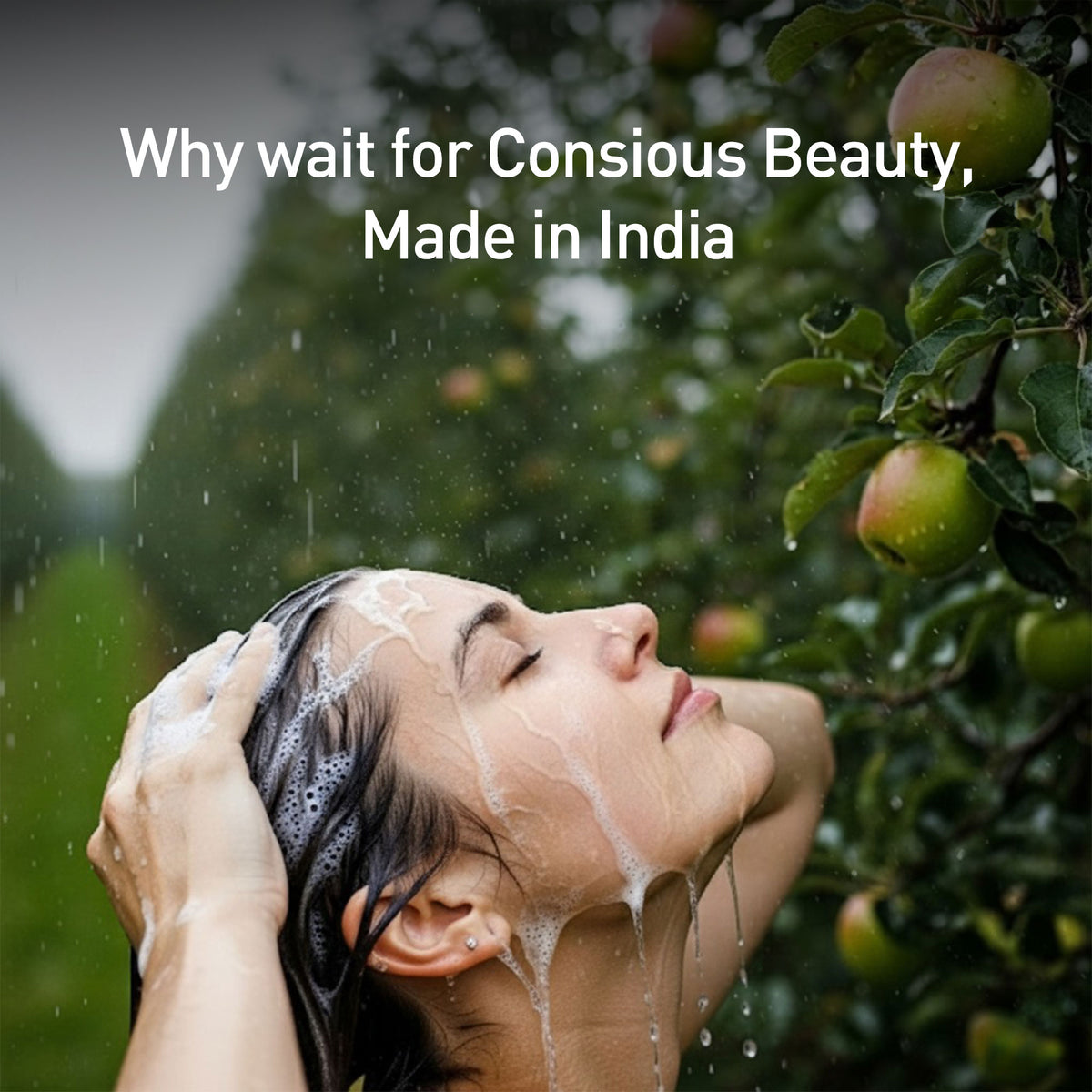 Person washing hair outdoors with apples on a tree in the background