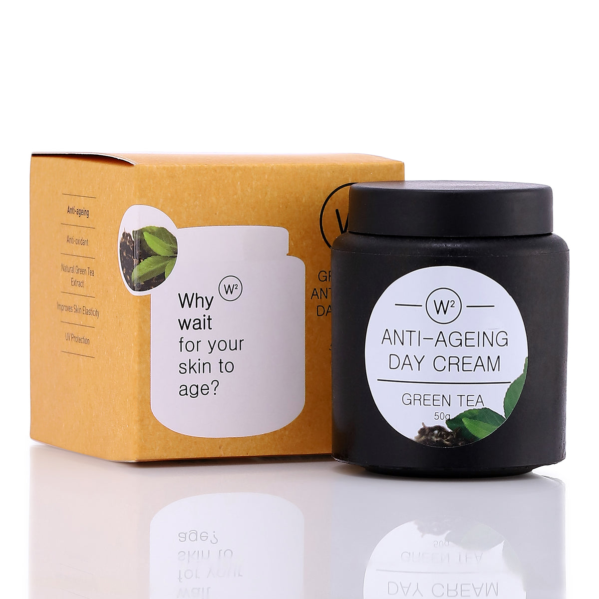 A jar of 'W2Why Wait Anti-Aging Day Cream' with green tea, next to its yellow packaging box with the same product name and image of green tea leaves on it.