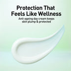 Anti-ageing day cream with a smooth texture on a light green background, featuring text about skin plumpness and protection.