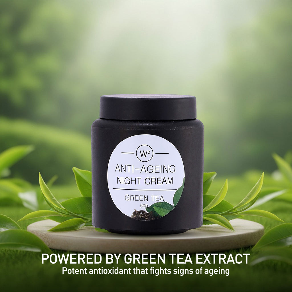 Anti-aging night cream jar with green tea leaves on a natural background