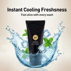 Black face wash tube with water splashes and mint leaves on a beige background