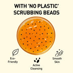 Orange scrub with black beads in a jar, labeled 'No Plastic Scrubbing Beads', on a beige background.