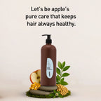 Brown bottle with a label, apple, leaves, and nuts on a light background